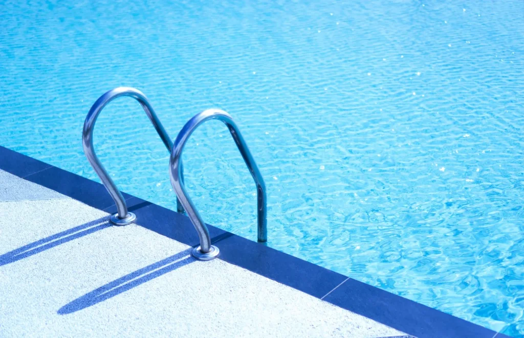 Metal ladder hooked over the top rail of an above ground pool