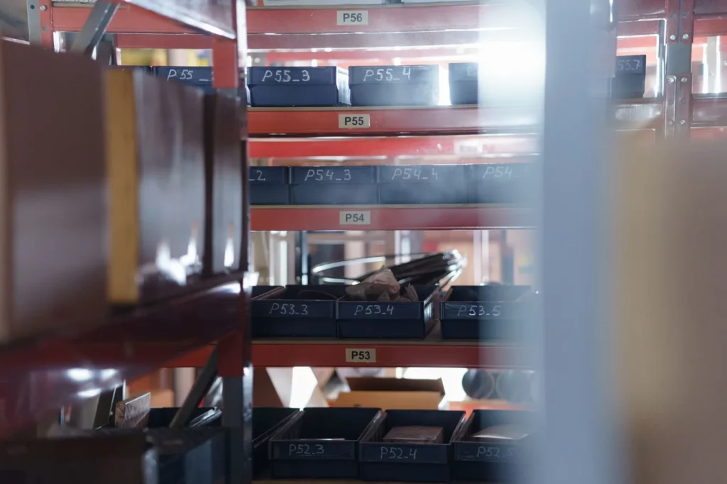 Pool gear stored in labeled bins on a shaded garage shelf
