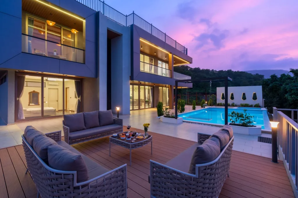 Empty pool deck with a charging cable coiled beside the water at dusk
