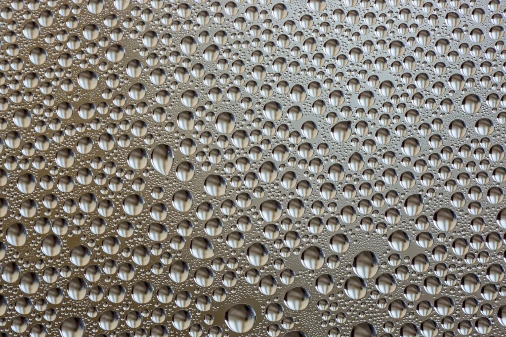 Close view of small metal charging contacts on a wet dock surface