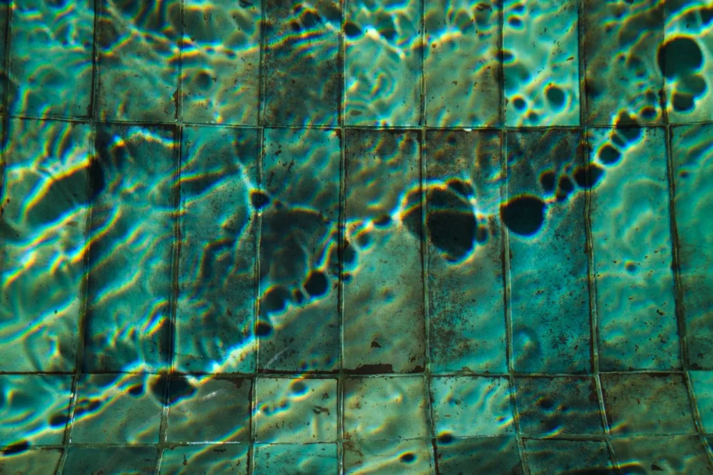 Sunlight rippling across a clean underwater pool wall and floor