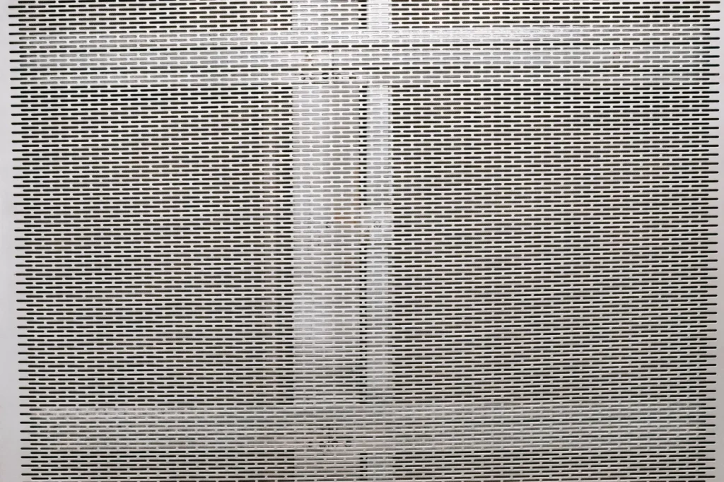 Close up of a clogged gray filter panel mesh caked with fine debris