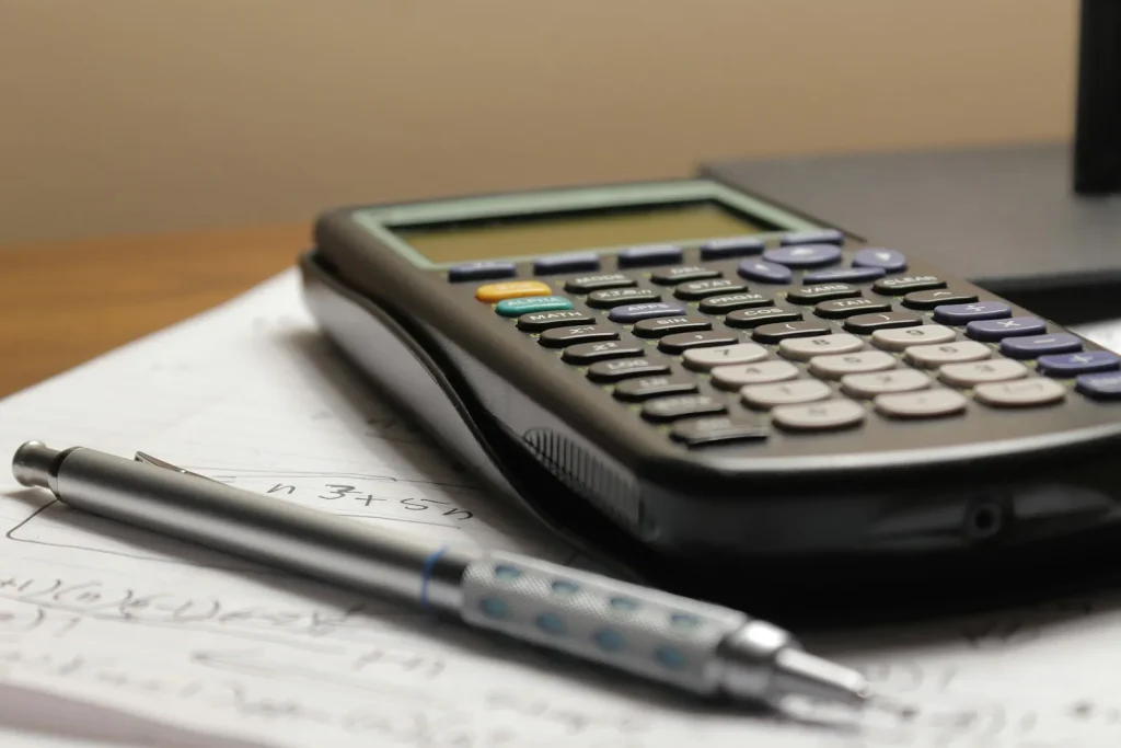 Calculator and notebook beside coffee for comparing repair costs